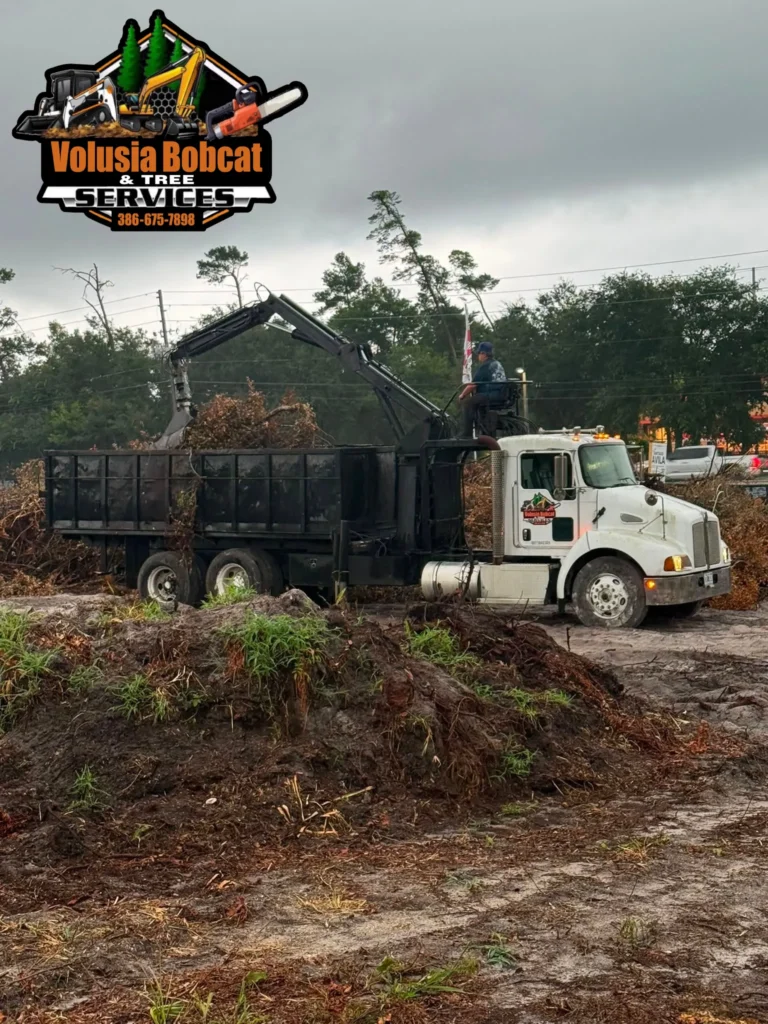 Volusia Bobcat & Tree Service grapple truck hauling storm debris in Volusia County, Florida, following